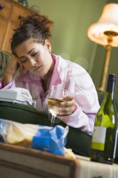 Royalty Free Photo of a Woman Waiting by the Phone With a Bottle of Wine