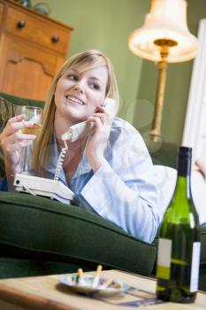 Royalty Free Photo of a Young Woman on the Phone Sipping Wine