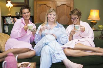 Royalty Free Photo of Young Women on the Sofa Drinking Tea