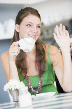 Royalty Free Photo of a Woman Drinking Tea and Waving