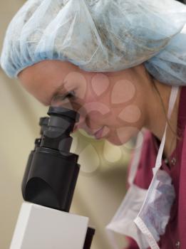 Royalty Free Photo of a Woman Looking Into a Microscope