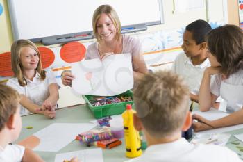 Royalty Free Photo of a Teacher Showing a Drawing to a Class