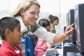 Royalty Free Photo of a Teacher Helping a Child at a Computer