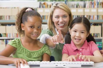 Royalty Free Photo of Two Students at a Computer With Their Teacher