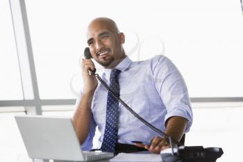 Royalty Free Photo of a Man in an Office Talking on the Phone