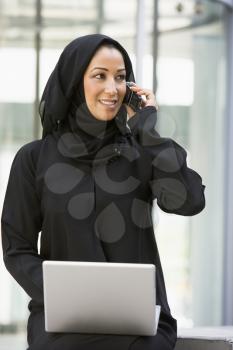 Royalty Free Photo of a Woman With a Laptop and Cellphone