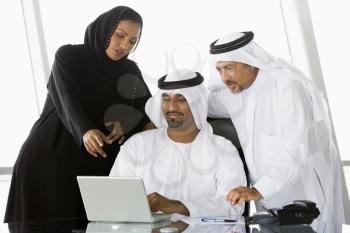 Royalty Free Photo of Two Men and a Woman Looking at a Laptop