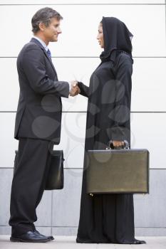 Royalty Free Photo of a Western Man Shaking Hands With an Eastern Woman
