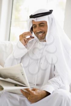 Royalty Free Photo of a Man With a Newspaper and Cellphone