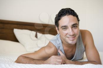 Royalty Free Photo of a Man Resting on a Bed