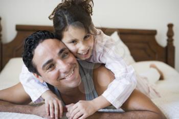 Royalty Free Photo of a Father and Daughter on the Bed