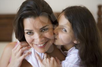 Royalty Free Photo of a Young Girl Kissing a Woman on the Cheek