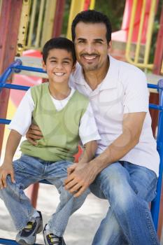 Royalty Free Photo of a Father and Son on Playground Equipment