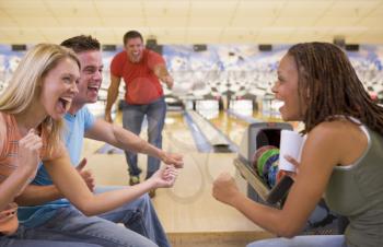Royalty Free Photo of a Man Bowling With Friends