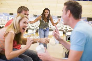 Royalty Free Photo of a Woman Bowling With Friends
