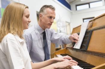 Royalty Free Photo of a Girl With the Teacher at the Piano