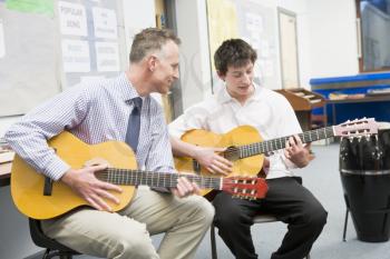 Royalty Free Photo of a Teache and Guitar Student
