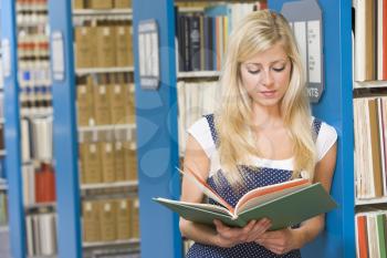 Royalty Free Photo of a Girl Reading in a Library