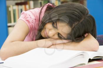 Royalty Free Photo of a Girl Sleeping in a Library