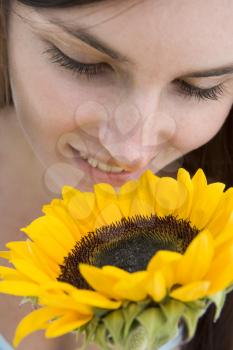 Royalty Free Photo of a Girl Smelling a Sunflower