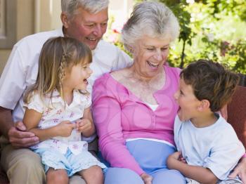 Royalty Free Photo of Grandparents Laughing With Their Grandchildren