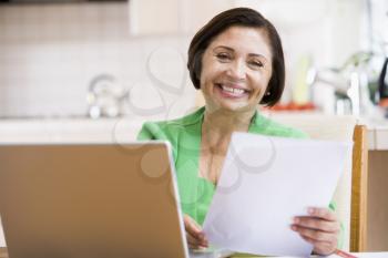 Royalty Free Photo of a Woman With a Laptop and a Piece of Paper