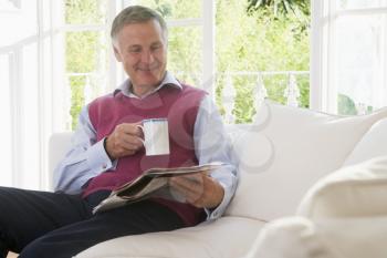 Royalty Free Photo of a Man With a Coffee and Newspaper