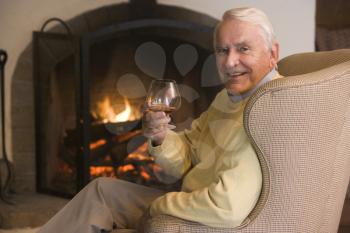 Royalty Free Photo of a Man by the Fire With a Drink
