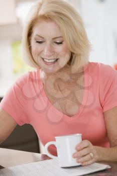 Royalty Free Photo of a Woman With a Cup and Newspaper