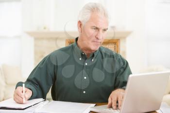Royalty Free Photo of a Man Doing Paperwork at a Laptop