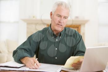 Royalty Free Photo of a Man Doing Paperwork at a Laptop