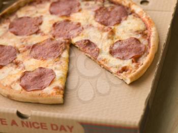 Royalty Free Photo of a Pepperoni Pizza With a Slice Missing