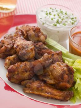 Royalty Free Photo of Spicy Buffalo Wings with Bleu Cheese Dip Celery and Hot Chili Sauce