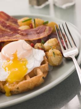 Royalty Free Photo of Waffles with Bacon, Fried Potatoes and a Broken Fried Egg