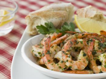 Royalty Free Photo of a Dish of Garlic Buttered Tiger Prawns With Rustic Bread