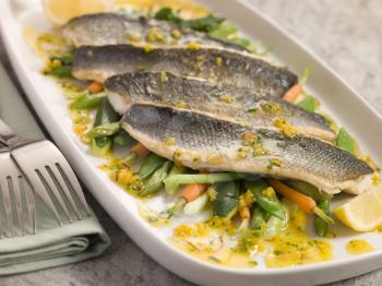 Royalty Free Photo of Fillets of Sea bass with Baby Vegetables and Saffron Butter