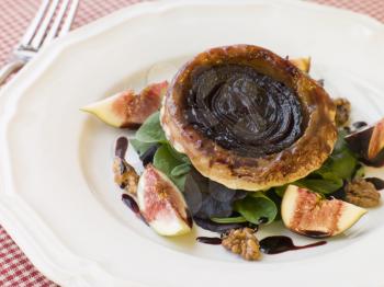 Royalty Free Photo of Red Onion Tarte Tatin with Walnuts Figs and Red Wine Syrup