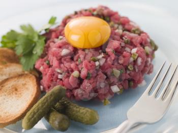 Royalty Free Photo oSteak Tartare With Cornichons, Croutons and an Egg Yolk