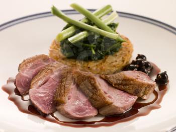 Royalty Free Photo of Breast of Duck With Rosti Potato and Cassis Jus