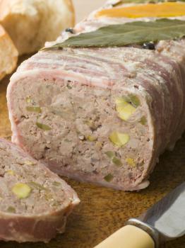 Royalty Free Photo of of Pate Campagne on a Chopping Board with Rustic Bread