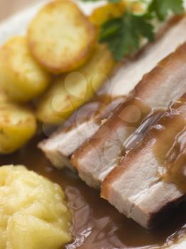 Royalty Free Photo of Roasted Belly Pork with Fried Potatoes and Apple Sauce