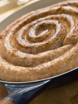 Royalty Free Photo of a Cumberland Sausage Coil in a Frying Pan