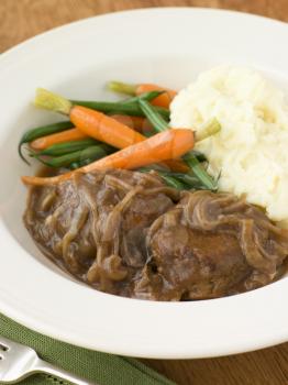 Royalty Free Photo of Faggots in Onion Gravy with Mashed Potato and Vegetables