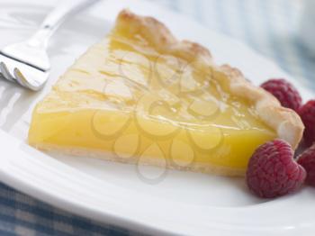 Royalty Free Photo of a Slice of Lemon Curd Tart with English Raspberries