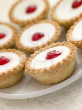 Royalty Free Photo of a Plate of Cherry Bakewell Tarts