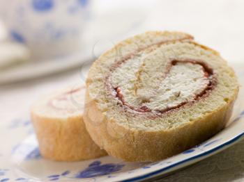 Royalty Free Photo of Cream and Strawberry Sponge Roll With Tea