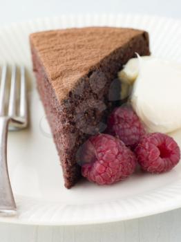 Royalty Free Photo of a Chocolate Sponge Cake With Whipped Cream and Raspberries