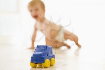 Royalty Free Photo of a Little Baby On the Floor With a Toy Truck