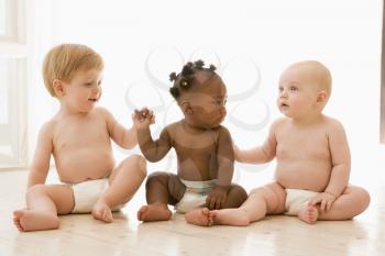 Royalty Free Photo of Three Babies Sitting on the Floor