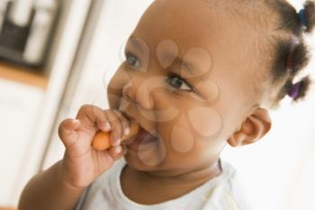 Royalty Free Photo of a Little Girl Eating a Carrot